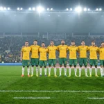 Socceroos players in green and gold lining up before a World Cup 2026 qualifier